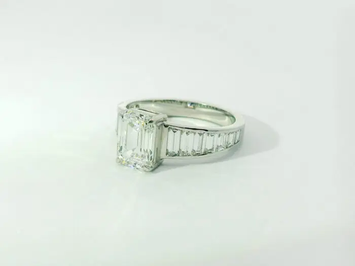 Gabrielle emerald center with graduated trapezoid ring
