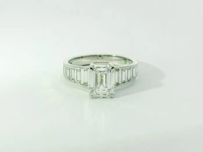 Gabrielle emerald center with graduated trapezoid ring