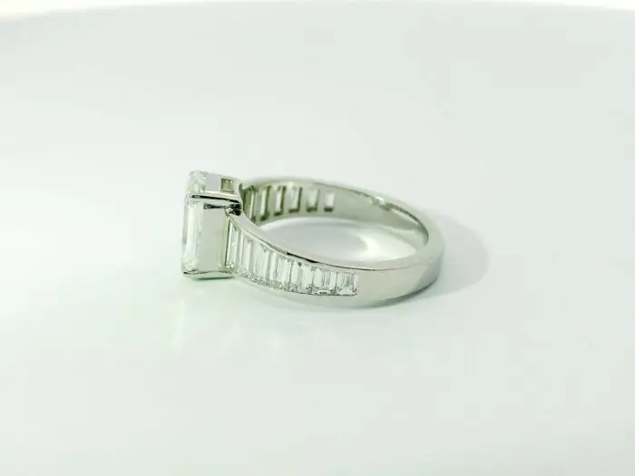 Gabrielle emerald center with graduated trapezoid ring